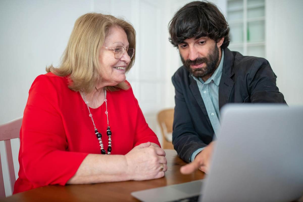 Coach having a professional conversation with clients on laptop for telegram group for coaches
