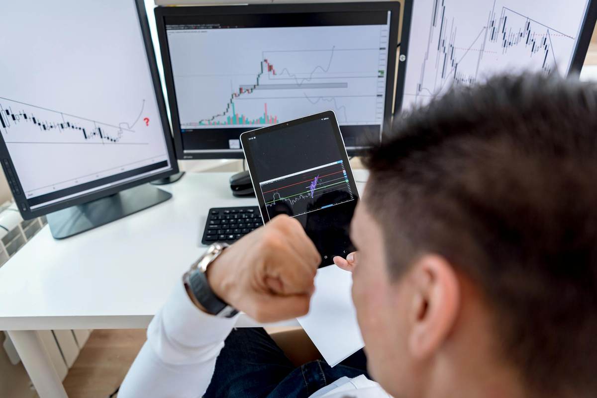 Professional trading setup with multiple screens showing market data for a finance Telegram channel