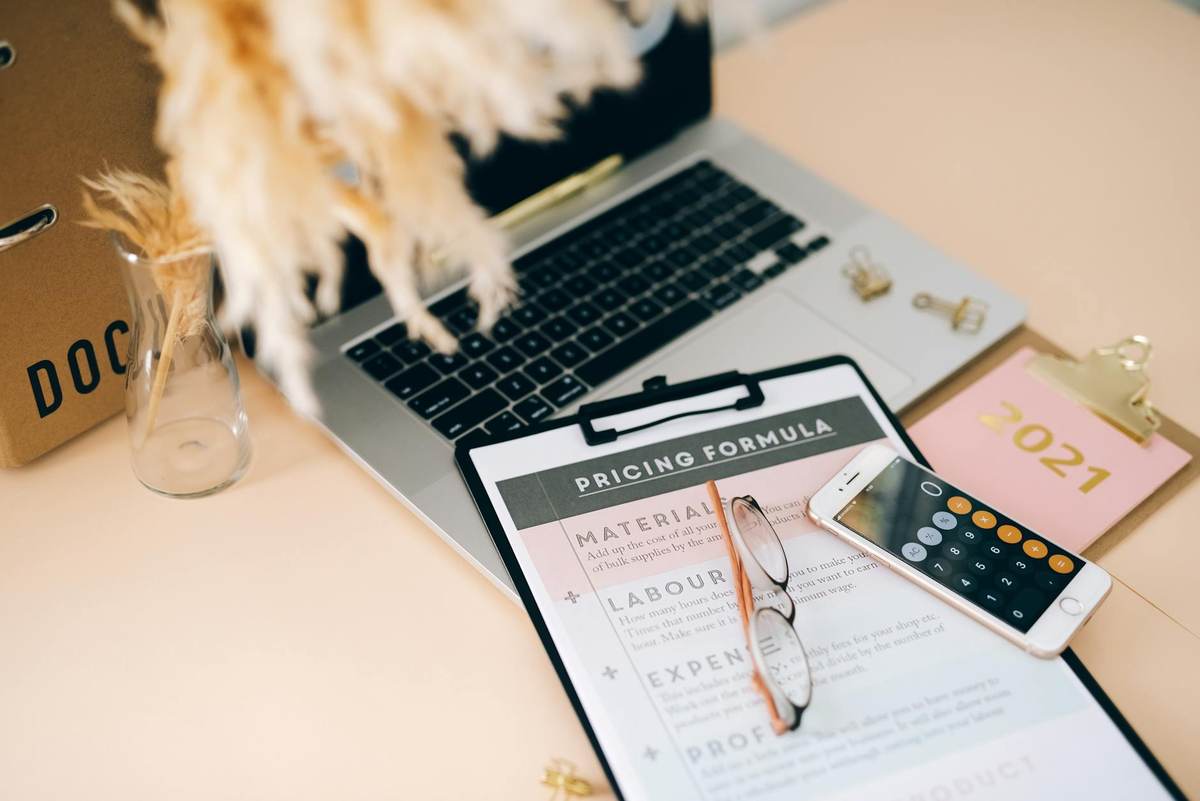 Person calculating message pack pricing strategy on laptop