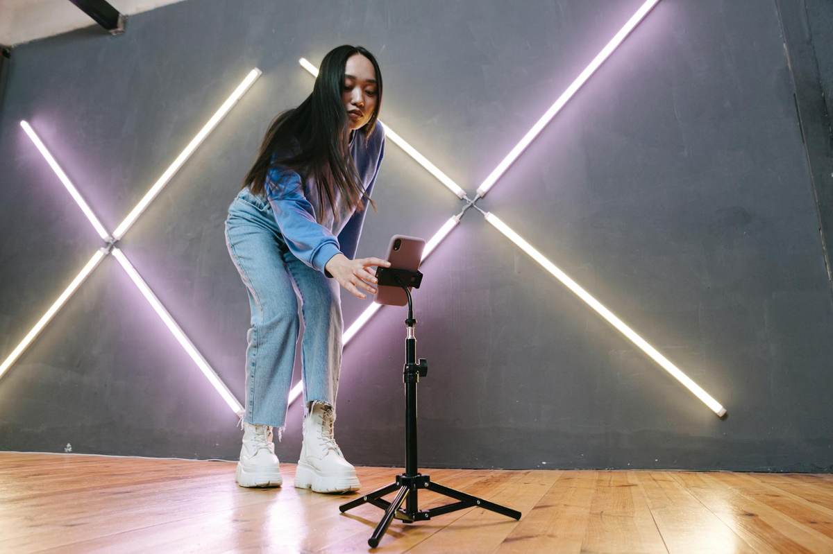 Content creator working on smartphone in professional studio for telegram exclusive content production